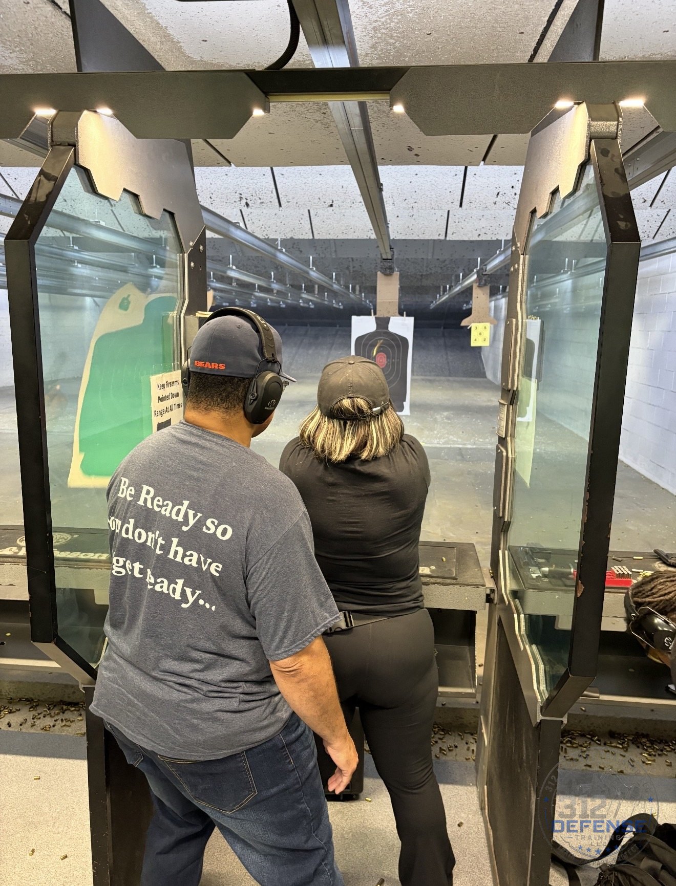 Instructor supervising a student during handgun range practice